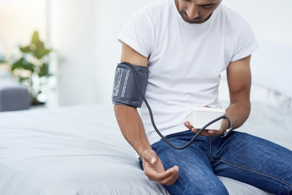 Chico midiéndose la tensión arterial para saber cómo podemos prevenir los infartos